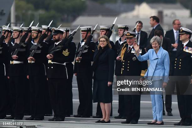 Britain's Prime Minister Theresa May waves beside Britain's Defence Secretary and Minister for Women and Equalities Penny Mordaunt on board the HMS...