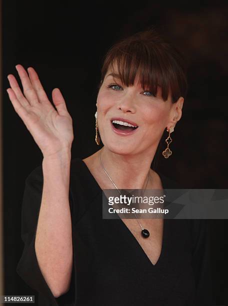 French First Lady Carla Bruni-Sarkozy waves to photographers before entering Le Ciro's Resaturant to have lunch with the spouses of heads of state on...