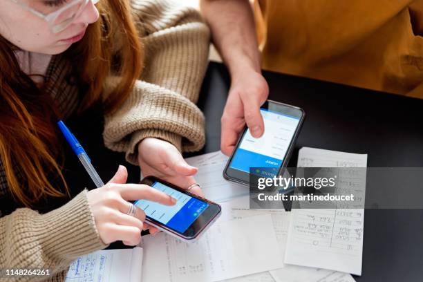 duizendjarige echtpaar met behulp van digitale betaling te delen kosten. - internetbankieren stockfoto's en -beelden