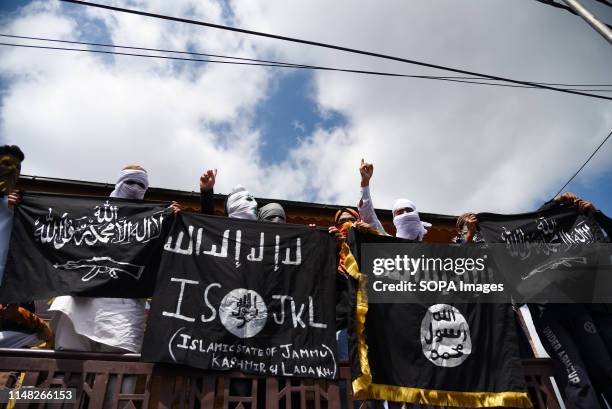 Kashmiri Protesters hold ISIS flags while making gestures during a protest in Srinagar. Indian forces in Srinagar used teargas smoke canisters and...