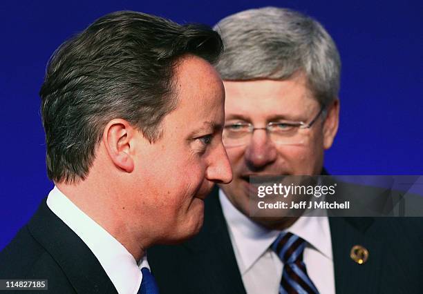 British Prime Minister, David Cameron, stands next to Canadian Prime Minister, Stephen Harper, during the G8 family photo on May 27, 2011 in...