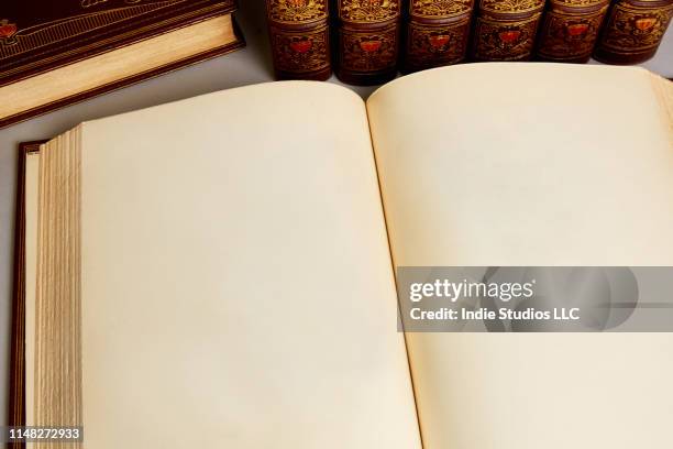 an old book with blank pages sits with collection of antique rare and old leather bound books from the 19th century - libro viejo fotografías e imágenes de stock