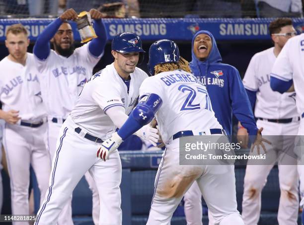 Vladimir Guerrero Jr. #57 of the Toronto Blue Jays is congratulated by Randal Grichuk after hitting a three-run home run in the eighth inning during...