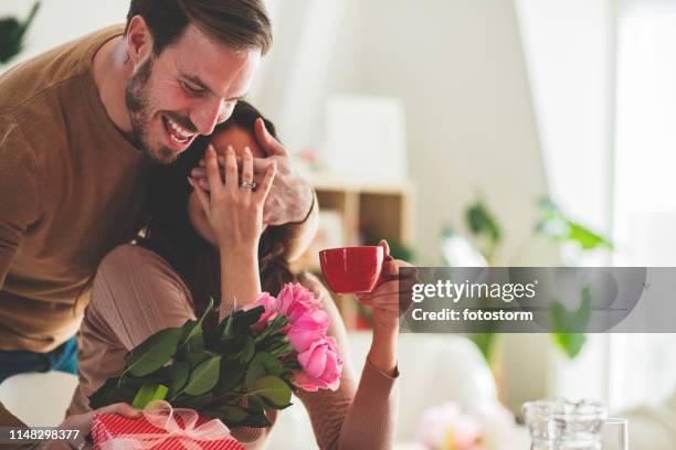 man surprising his girlfriend with flowers - valentine's day home stock pictures, royalty-free photos & images