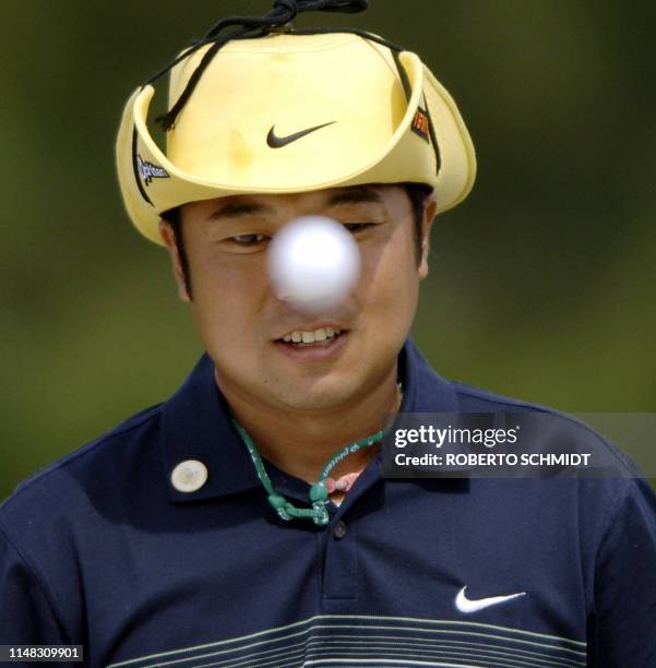 Shingo Katayama of Japan tosses a golf ball onto the green 06 April 2005 during the third practice round for the 2005 Masters Golf Tournament at the...