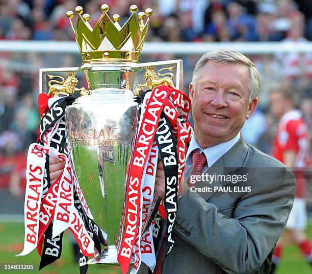 Manchester United's Scottish manager Sir Alex Ferguson celebrates with the English Premier League trophy after their match against Blackpool at Old...