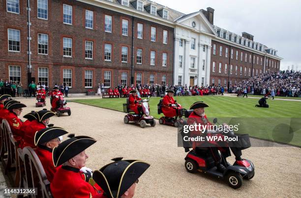 Chelsea Pensioners drive mobility scooters during the annual Founder's Day parade at Royal Hospital Chelsea on June 6, 2019 in London, England.