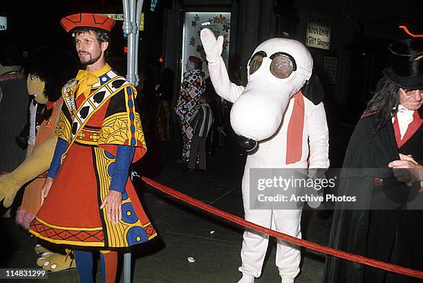 Extras dressed in costume, including one as Snoopy during an event for the film 'Alice's Adventures in Wonderland', c. 1973.