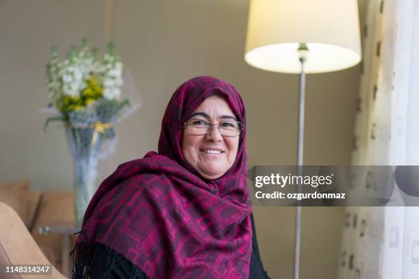 muslimische frau im wohnzimmer - arab old woman stock-fotos und bilder