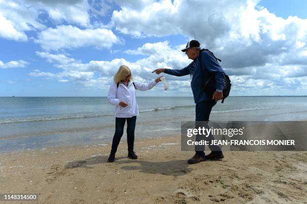 Veteran Michael Cassady and her wife Sharon collect shells at Utah Beach, in Sainte-Marie-du-Mont, northwestern France, on June 6 as part of D-Day...