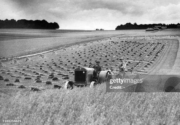 Tranquil scene near Stonehenge on Salisbury Plain as harvesting started on July 29th, 1938. Owing to the exceptionally dry summer, all the corn on...