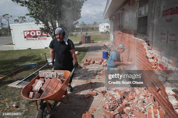 Wesley Johnson and Justin Weisbrod remove a layer of brick from a home being restored after it was heavily damaged by Hurricane Michael on May 10,...