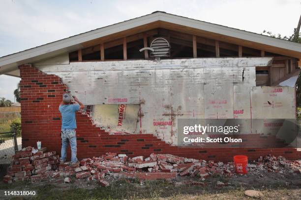 Wesley Johnson removes a layer of brick from a home being restored after it was heavily damaged by Hurricane Michael on May 10, 2019 in Panama City,...