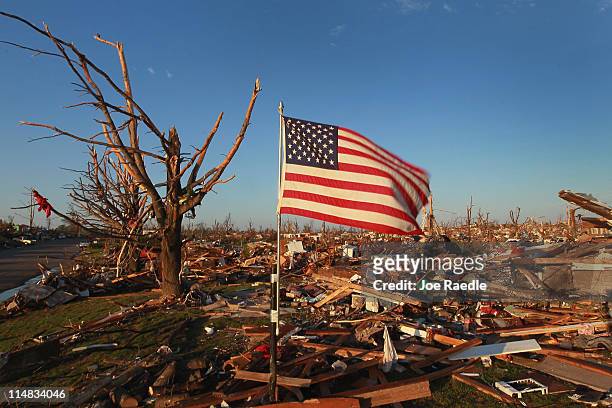 An American flag stands among the debris from homes that were destroyed by a massive tornado on May 27, 2011 in Joplin, Missouri. At least 125 were...