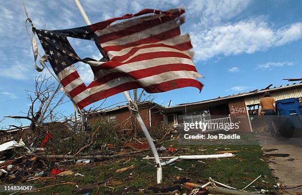 Torn American flag hangs on a pole outside of a house that was damaged during a massive tornado on May 27, 2011 in Joplin, Missouri. At least 125...