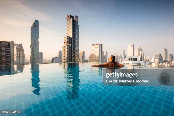 beautiful woman in an infinity pool, bangkok, thailand - thailand skyline stock pictures, royalty-free photos & images