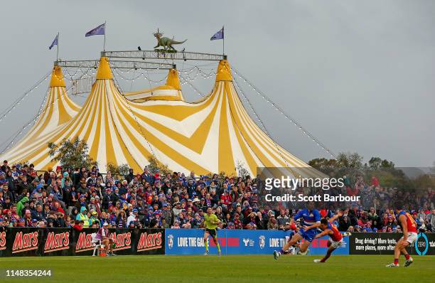 Marcus Bontempelli of the Bulldogs runs with the ball as the circus takes place next to the ground during the round eight AFL match between the...