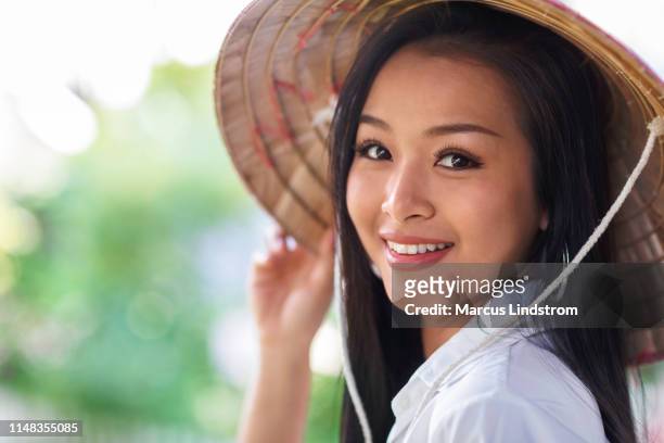 thailändische frau mit einem asiatischen kegelhut - thai ethnicity stock-fotos und bilder