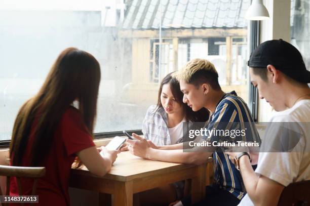 friends using their phones in a cafe - daily life in philippines stock pictures, royalty-free photos & images