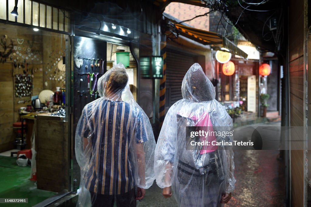 Tourist couple walking through the streets of Jiufen