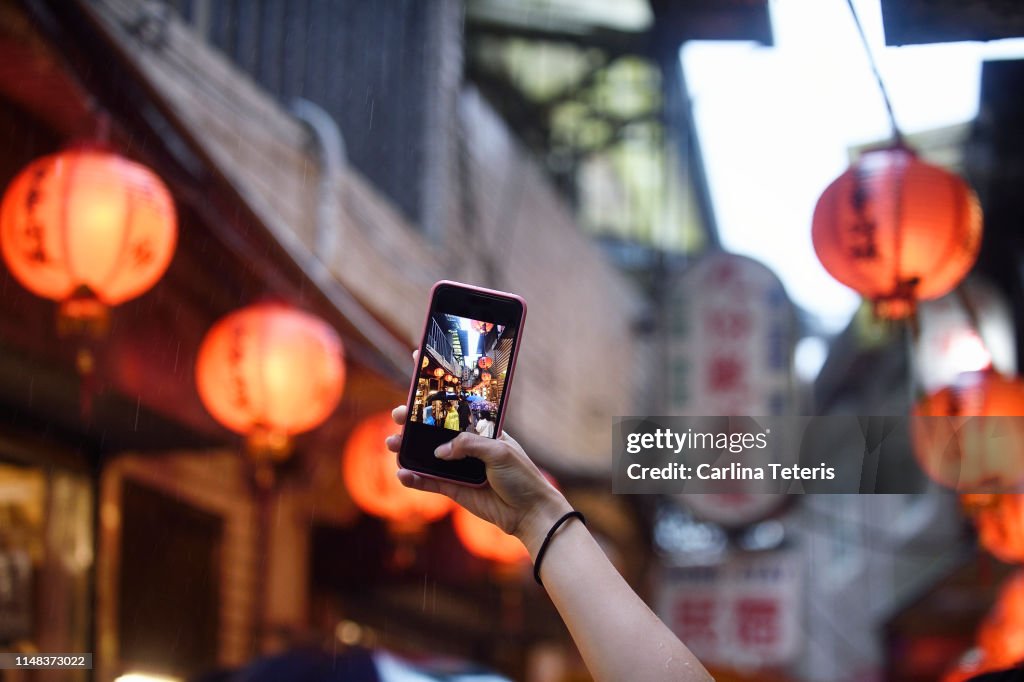 Hand taking a picture of Chinese Lanterns with a smart phone