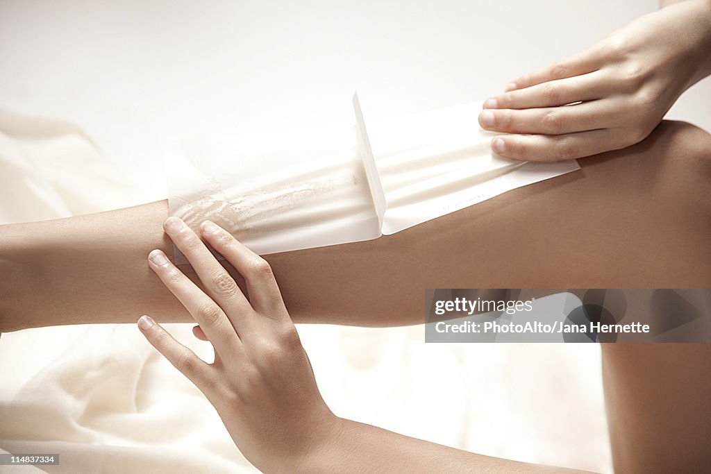 Woman waxing legs, cropped