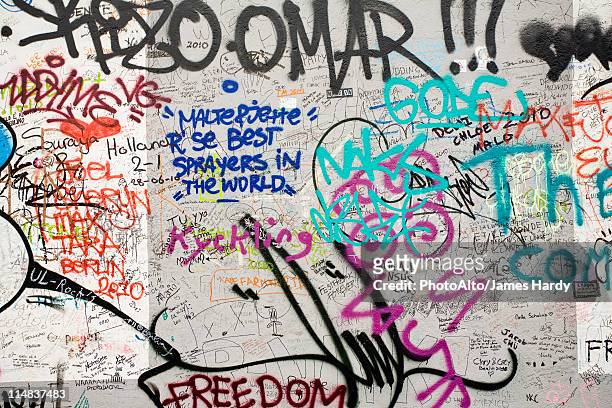 graffiti covering a section of the berlin wall, berlin, germany - against wall stock-fotos und bilder