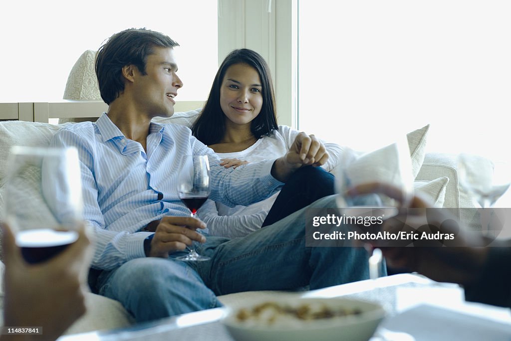 Couple enjoying red wine with friends