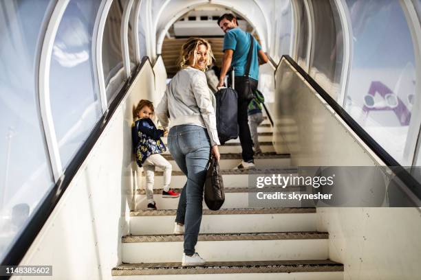 happy family moving up the staircase towards the plane. - airport stairs stock pictures, royalty-free photos & images