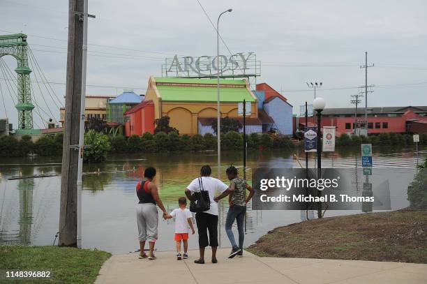 Family looks on at floodwaters along a submerged road on June 6, 2019 in Alton, Illinois. Residents along the Mississippi River are bracing for the...