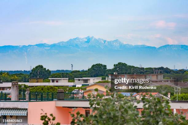 a view of the julian alps at sunrise from a rooftop of a building, bibione, veneto, italy - bibione stock pictures, royalty-free photos & images