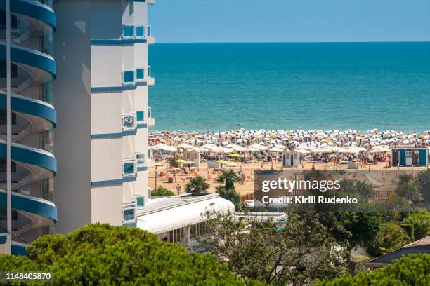 sunlit beach and hotel building by the adriatic sea, bibione, italy - bibione stock pictures, royalty-free photos & images