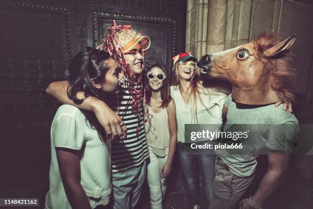 megaparty: freunde feiern wild auf den straßen - mask disguise stock-fotos und bilder