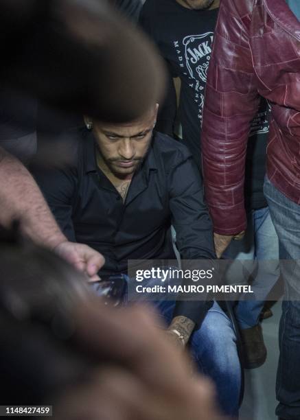 Brazil's star striker Neymar arrives using a wheelchair to the Police Station to give a statement for posting intimate WhatsApp messages with Najila...