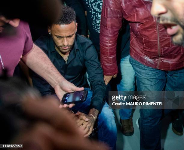 Brazil's star striker Neymar arrives using a wheelchair to the Police Station to give a statement for posting intimate WhatsApp messages with Najila...
