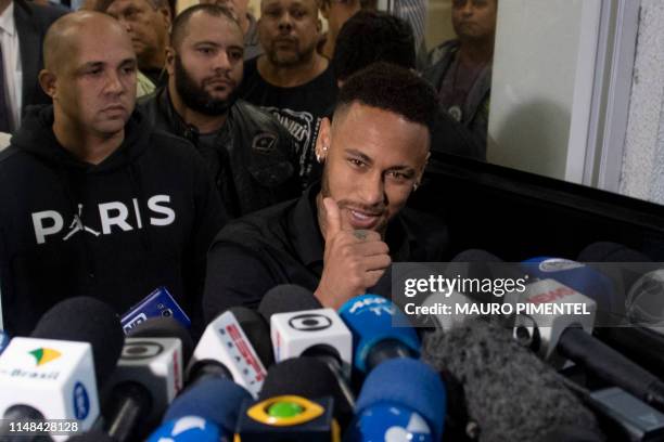 Brazil's star striker Neymar gives the thumb up as he leaves a Police Station after giving a statement to police for posting intimate WhatsApp...