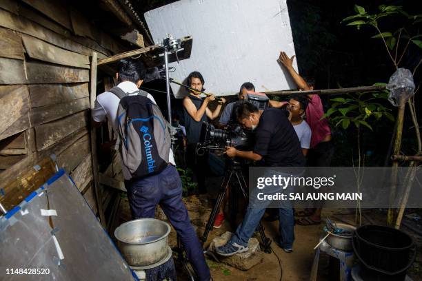 This photo taken on December 20, 2018 shows a film production crew shooting a movie on location in Yangon. A deadly race to find hidden treasure, car...