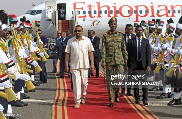 Ethiopia's Prime Minister Abiy Ahmed walks alongside Shams-Eddin Kabashi Sudan's Transitional Military Council spokesman upon his arrival at Khartoum...