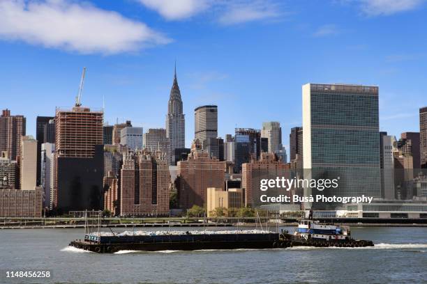 manhattan, east river waterfront: the united nations building. new york city, usa - barge fotografías e imágenes de stock