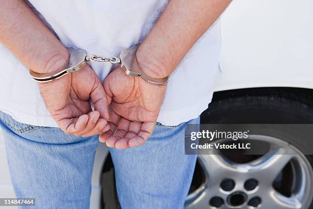 usa, illinois, metamora, midsection of man with handcuffs on hands - detainee fotografías e imágenes de stock