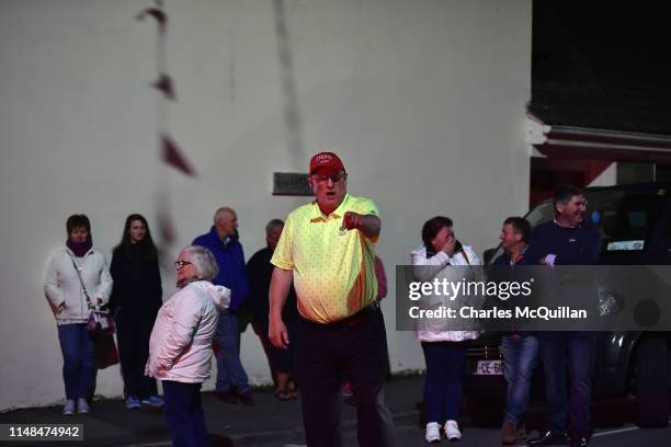 Trump supporter wearing a Trump 2020 hat gesticulates in the street as local residents wait in vain for a late night glimpse of US President Donald...