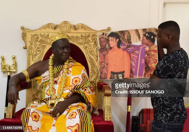 King Amon N'Douffou V, King of Krindjabo, capital of the Sanwi Kingdom, in the southeast of the Ivory Coast, looks at a portrait of US pop star the...