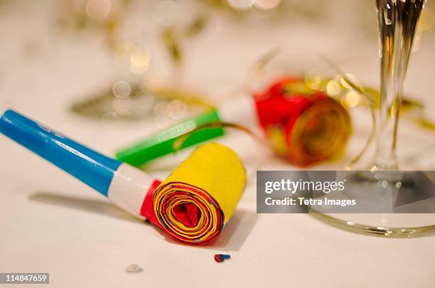 party horn blower and champagne flute on table, close-up - party blower stock-fotos und bilder