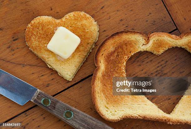 heart shaped toast on table - bread love stockfoto's en -beelden