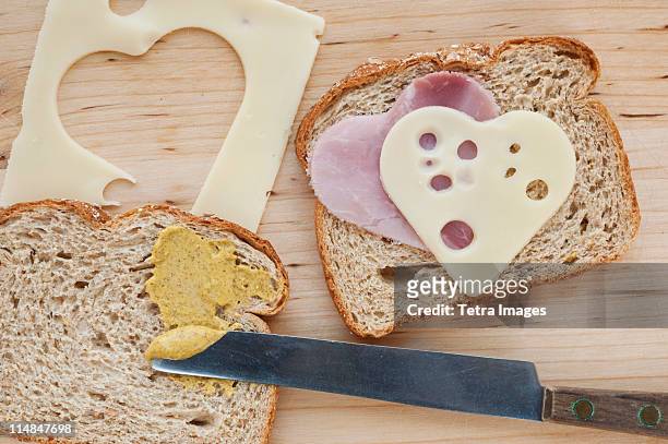 sandwich with heart shaped slices of meat and cheese - making a sandwich stockfoto's en -beelden