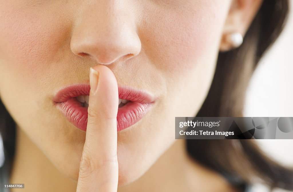 Young woman with finger on lips, close-up