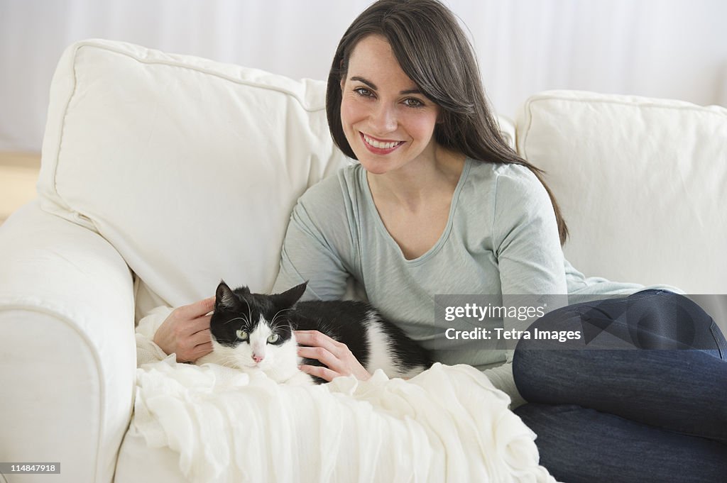 USA, New Jersey, Jersey City, portrait of woman with cat on sofa