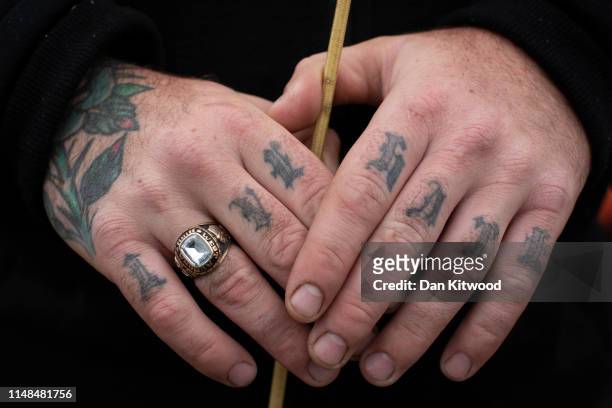 A man with 'Love and Hate' tattoos on his knuckles holds a whip... News  Photo - Getty Images
