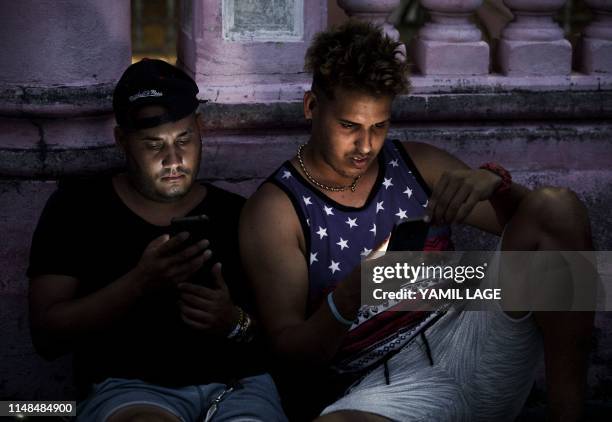 Young Cubans connect to internet from their mobile phone in Havana, on June 6, 2019. - Cubans do not hide their frustration six months after the...