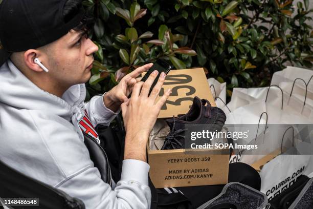 Young man shows off his new Yeezy Boost model designed by Kanye West. The German manufacturer of sports shoes Adidas has launched the limited edition...